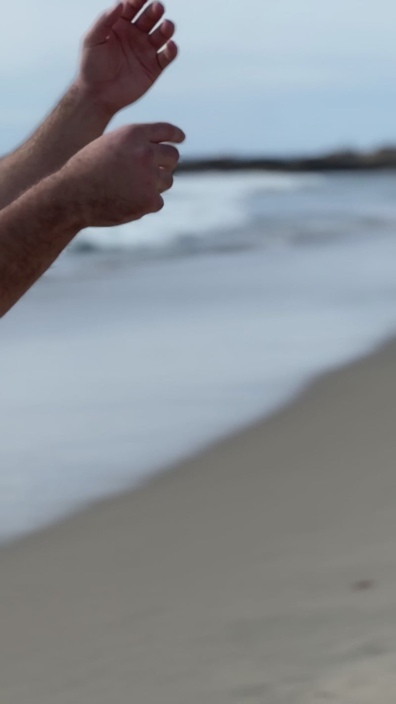 Mako Vitality Cotton Candy Grape sea moss gel in a glass jar on a sandy beach held in hand